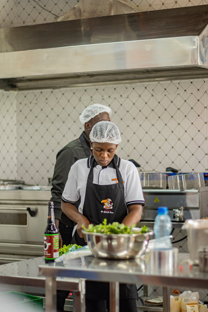Two chefs busy preparing dishes in a professional kitchen in Nakuru, Kenya.