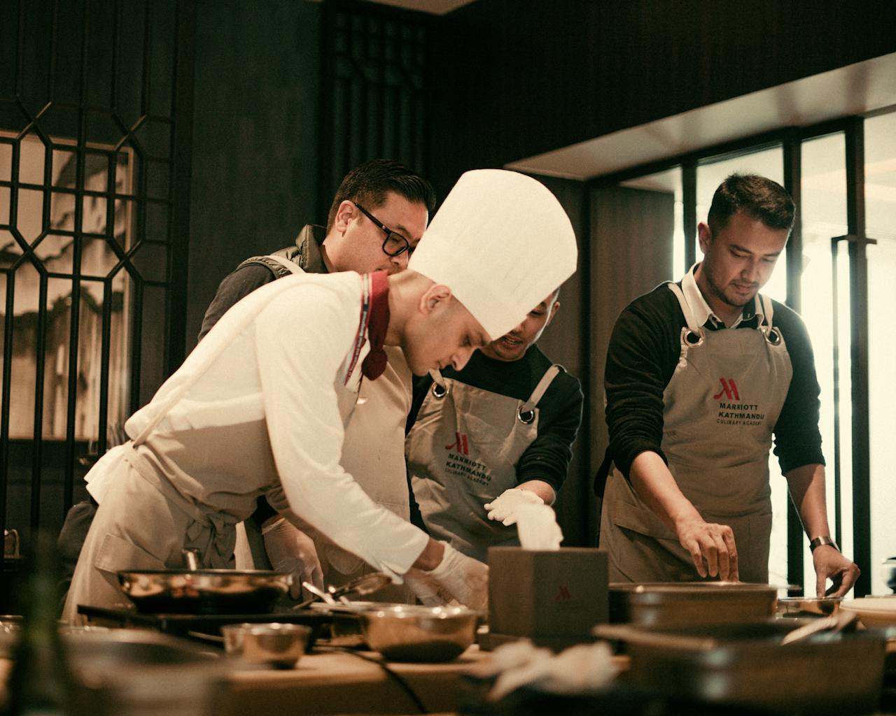 Team of chefs working together in a modern restaurant kitchen, preparing gourmet dishes with precision and skill.